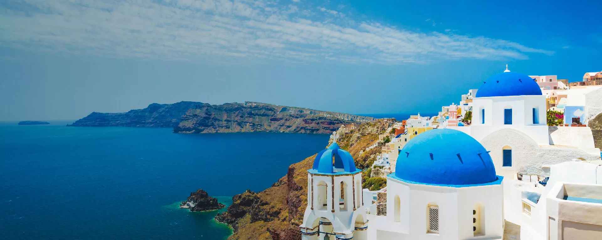 Santorin weiße Häuser mit blauer Dachkuppel direkt am Meer